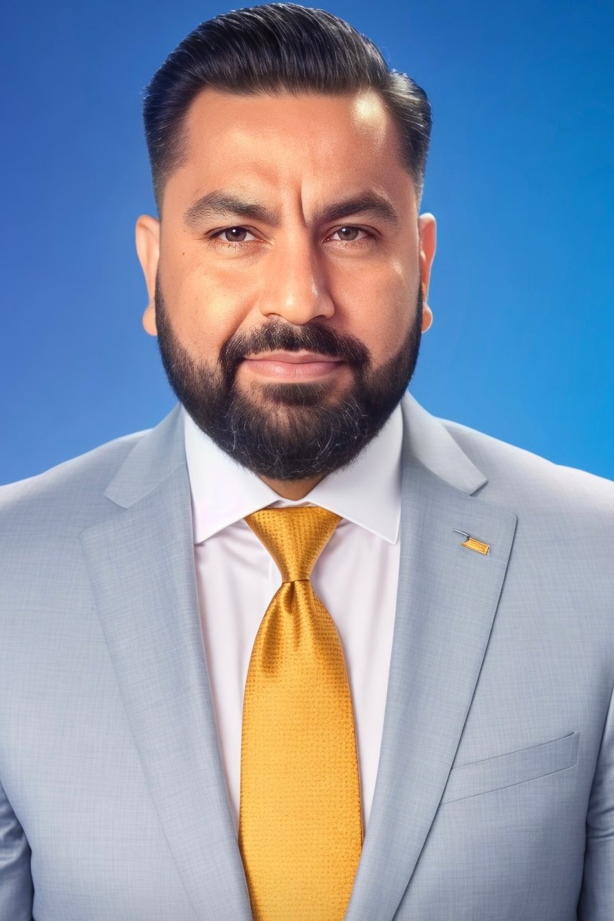 Junaid Younas wearing a light gray suit and gold tie